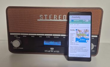 Starwaves DRM radio with a smartphone in front of it, playing the EduTab podcast via the radio’s built-in Wi-Fi hotspot.